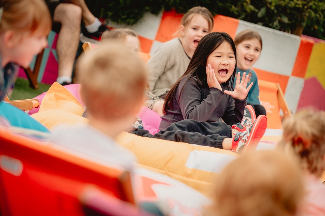 Children sat outside on bean bags and deck chairs