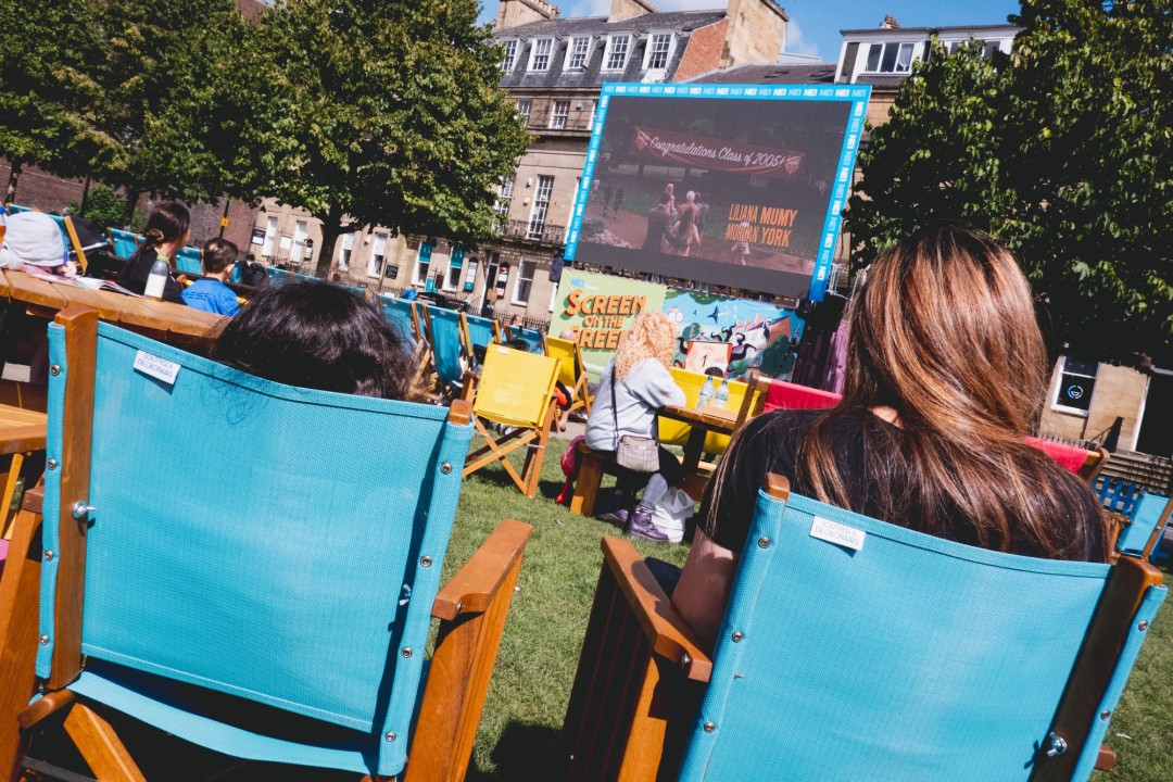 A women and child sitting in deckchairs watching a film on an open-air cinema screen at Newcastle’s Eldon Square