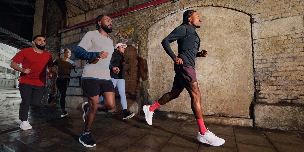 Five people running through a tunnel